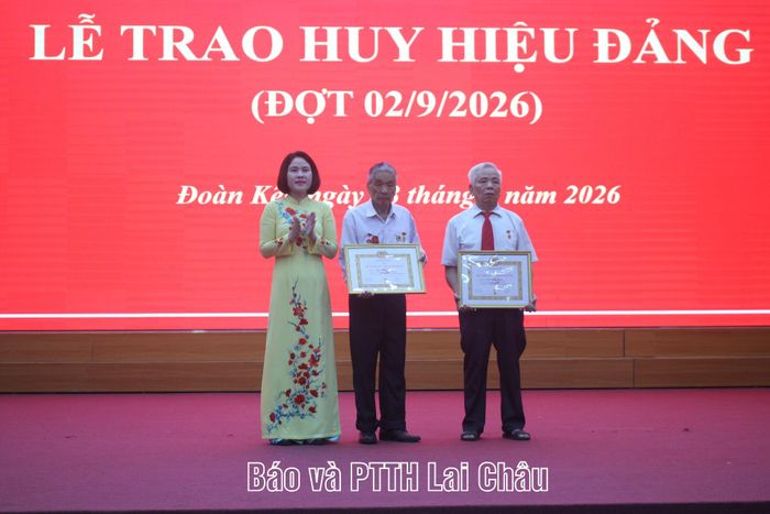 Bí thư Đảng ủy phường Đoàn Kết Đào Thị Lan Anh trao Huy hiệu 55 năm tuổi Đảng cho 2 đảng viên: Chúng Văn Him và Lê Xuân Bính.