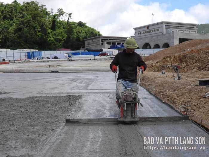 Công nhân đơn vị thi công thực hiện tạo phẳng mặt đường đoạn khớp nối công trình mở rộng đường xuất nhập khẩu hàng hóa chuyên dụng 