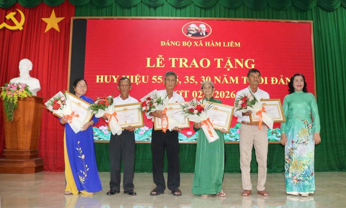 Các đồng chí đảng viên 55 năm, 45 năm tuổi Đảng nhận Huy hiệu Đảng và hoa từ Bí thư Đảng ủy xã