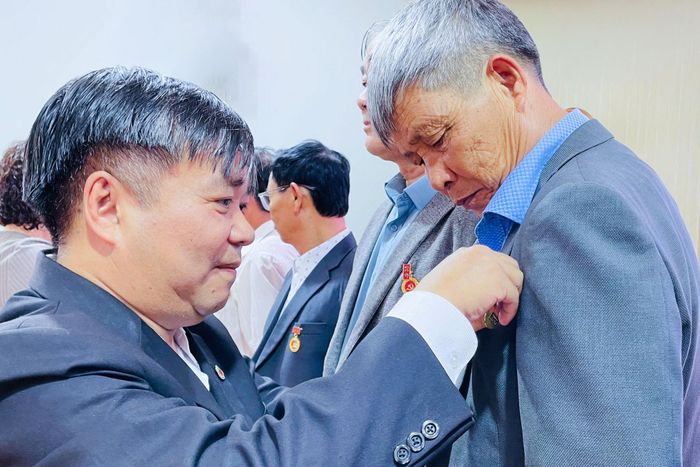 Đồng chí Đỗ Quốc Tuân, Phó Bí thư Thường trực Đảng ủy xã trao Huy hiệu Đảng cho các đảng viên
