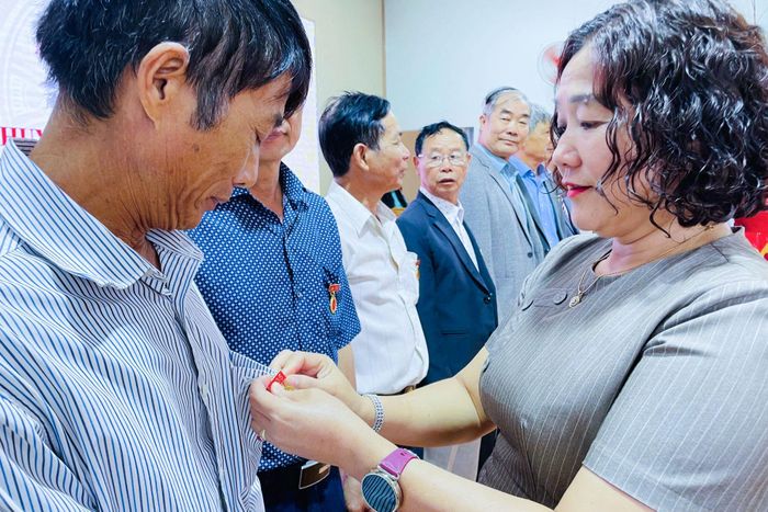 Đồng chí Đinh Thị Thu Thủy, Phó Bí thư Đảng ủy, Chủ tịch UBND xã trao Huy hiệu Đảng cho các đảng viên
