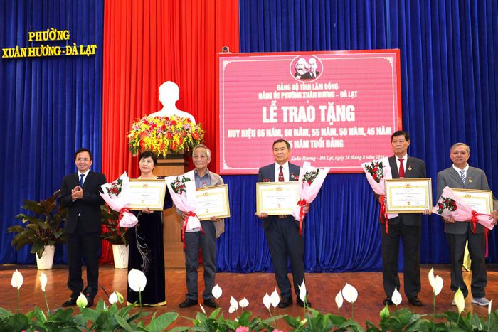 Tỉnh ủy viên, Bí thư Đảng ủy phường Xuân Hương - Đà Lạt Nguyễn Văn Lộc trao Huy hiệu 45 năm tuổi Đảng cho các đảng viên