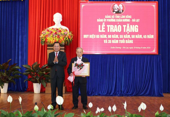 Đồng chí Tôn Thiện Đồng, Ủy viên Ban Thường vụ, Trưởng Ban Tổ chức Tỉnh ủy Lâm Đồng trao Huy hiệu 65 năm tuổi Đảng cho đảng viên