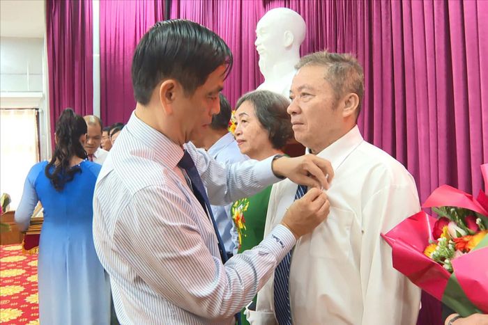 Đồng chí Võ Thanh Bình, Ủy viên Ban Thường vụ Tỉnh ủy, Bí thư Đảng ủy phường trao Huy hiệu Đảng cho đảng viên tại buổi lễ