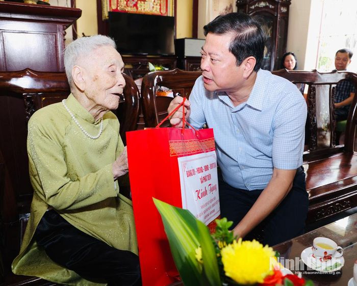 Đồng chí Lê Văn Kiên, Tỉnh ủy viên, Bí Thư Đảng ủy xã Phát Diệm tặng quà cụ Phạm Thị An, cán bộ Lão thành cách mạng.