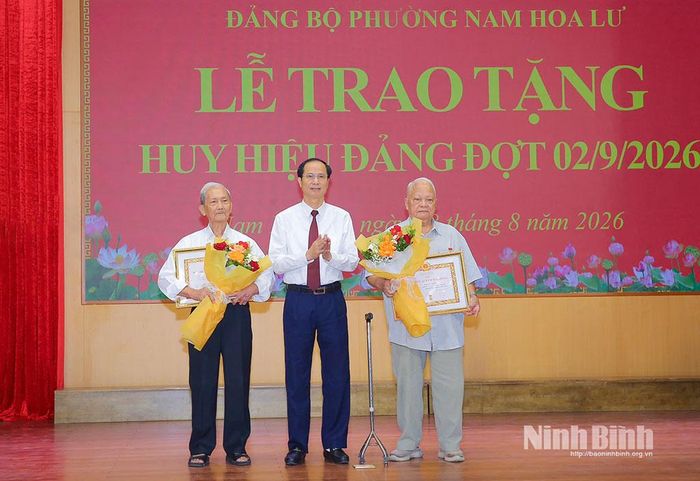 Đồng chí Bùi Thiện Thi, Tỉnh ủy viên, Bí thư Đảng ủy, Chủ tịch HĐND phường Nam Hoa Lư trao Huy hiệu 65 năm tuổi Đảng cho các đảng viên. Ảnh: Anh Tuấn