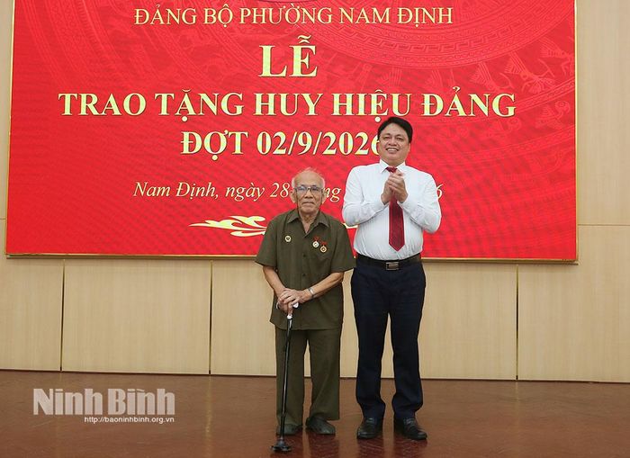 Đồng chí Trần Minh Thắng, Ủy viên Ban Thường vụ Tỉnh uỷ, Bí thư Đảng ủy, Chủ tịch HĐND phường Nam Định trao Huy hiệu 70 năm tuổi Đảng cho đảng viên Nguyễn Vũ Tảo. Ảnh: Trần Hồng Minh