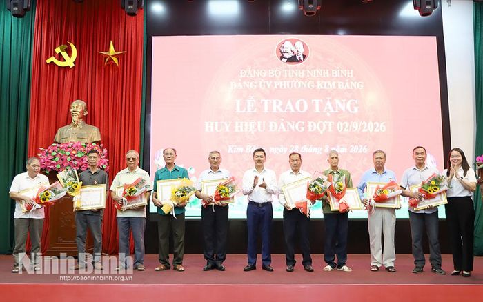 Lãnh đạo phường Kim Bảng trao tặng Huy hiệu Đảng cho các đảng viên. Ảnh: Nguyễn Oanh