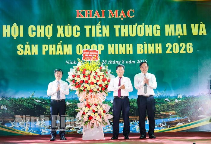 Các đồng chí Ủy viên Ban Thường vụ Tỉnh ủy: Trần Anh Dũng, Phó Chủ tịch UBND tỉnh; Đặng Thanh Sơn, Phó Chủ tịch UBND tỉnh tặng hoa chúc mừng Ban Tổ chức Hội chợ.