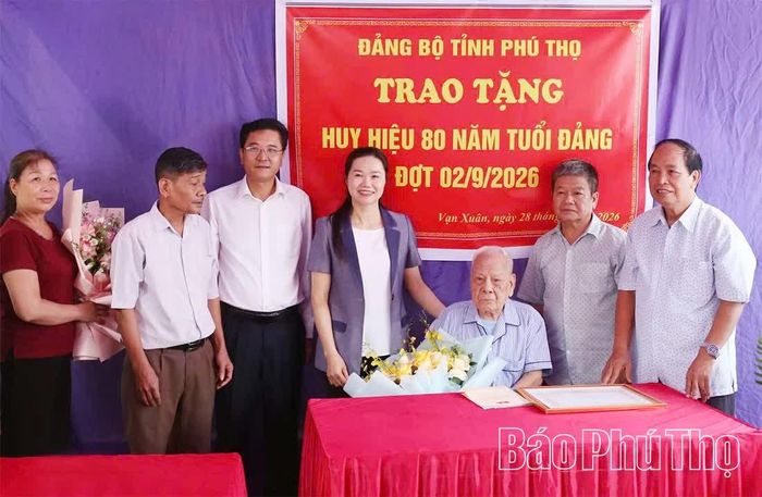 Phó Bí thư Tỉnh ủy, Chủ tịch Ủy ban MTTQ tỉnh Bùi Thị Minh chúc mừng đảng viên lão thành Đặng Xuân Dung được nhận Huy hiệu 80 năm tuổi Đảng.
