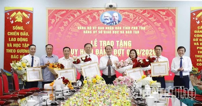 Các đồng chí lãnh đạo Sở Giáo dục và Đào tạo tặng hoa chúc mừng các đảng viên được nhận Huy hiệu Đảng.