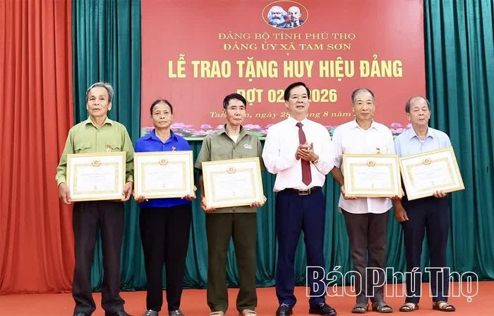 Bí thư Đảng ủy, Chủ tịch HĐND xã Tam Sơn trao Huy hiệu Đảng tặng các đảng viên.