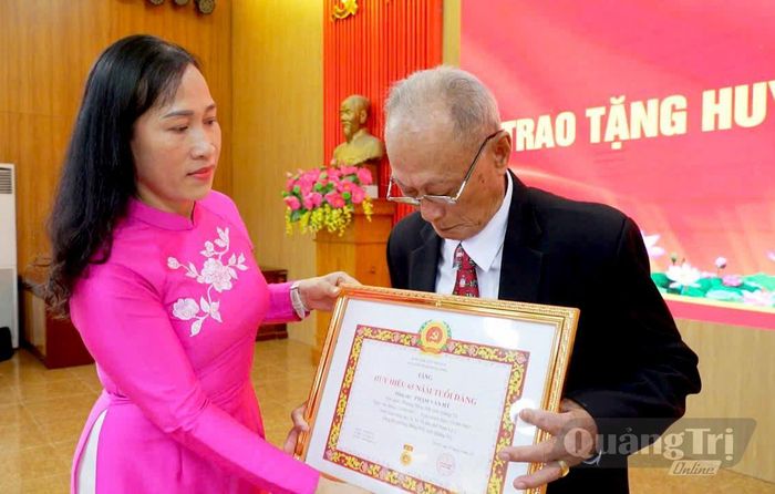 Đại diện lãnh đạo Đảng ủy phường Đồng Hới trao tặng Huy hiệu Đảng cho đảng viên lão thành - Ảnh: P.V