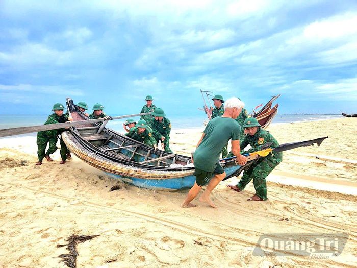 Cán bộ, chiến sĩ Đồn Biên phòng Hải An giúp ngư dân đưa tàu thuyền lên bờ, chủ động phòng, chống mưa bão - Ảnh: Quang Ngọc