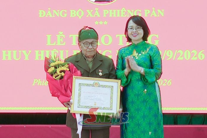 Đồng chí Đinh Thị Bích Thảo trao tặng Huy hiệu 60 năm tuổi Đảng cho đảng viên Lò Văn Út, Chi bộ bản Mật Sàng, Đảng bộ xã Phiêng Pằn.