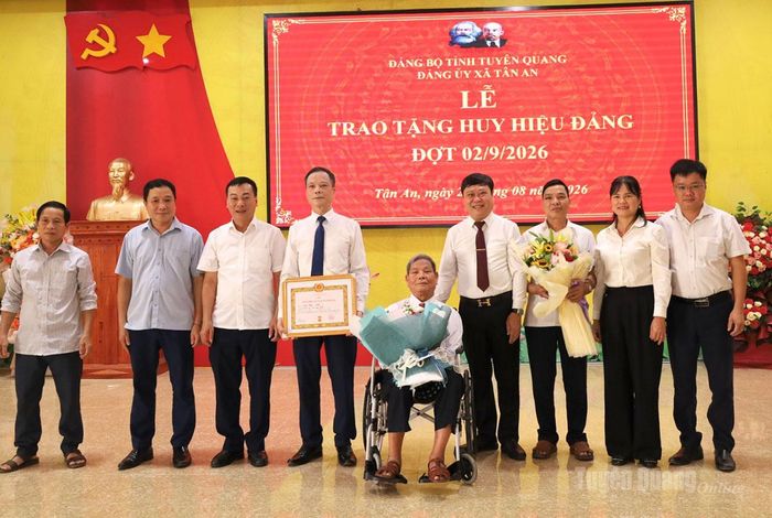 Các đại biểu tặng hoa, chụp ảnh lưu niệm cùng đảng viên Ma Phúc Nhót, Chi bộ thôn Tân Minh.
