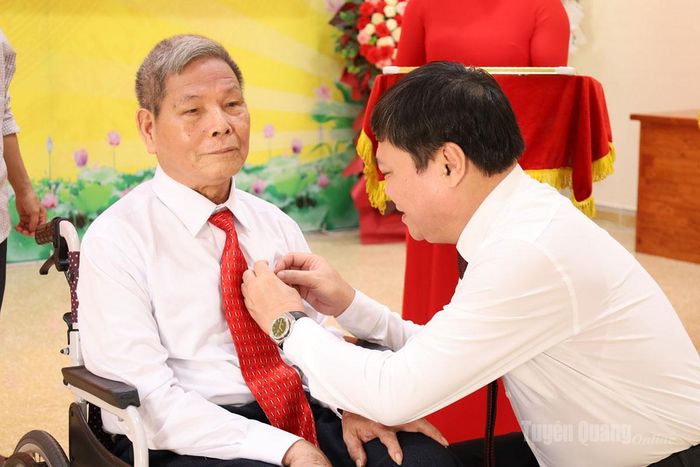 Đồng chí Mai Đức Thông trao Huy hiệu 60 năm tuổi Đảng cho đảng viên Ma Phúc Nhót, Chi bộ thôn Tân Minh.