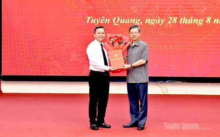 Đồng chí Nguyễn Văn Sơn, Chủ tịch HĐND tỉnh trao quyết định và tặng hoa đồng chí Đỗ Hùng Đức.