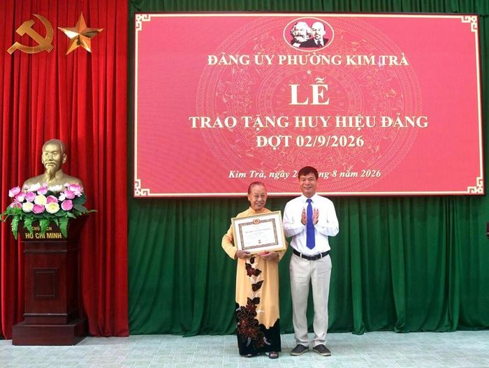  Bí thư Đảng ủy phường Kim Trà Châu Viết Thành trao Huy hiệu 55 năm tuổi Đảng cho đảng viên Trương Thị Chiên (tổ dân phố An Đô).
