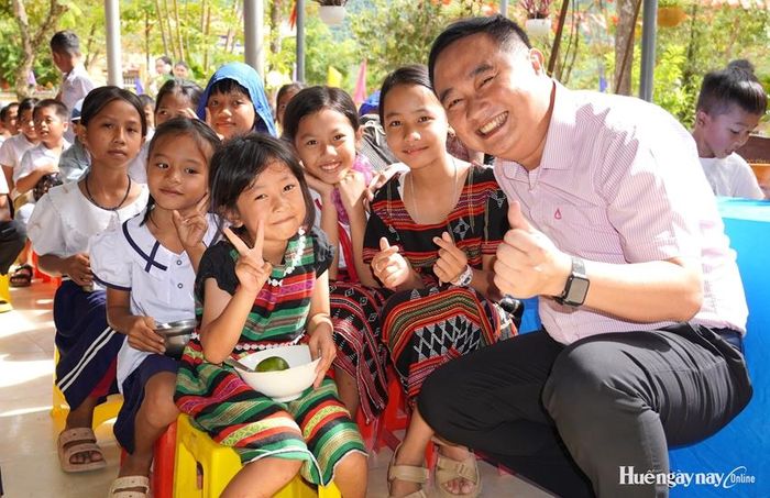 Các em nhỏ hào hứng chụp ảnh lưu niệm cùng các nhà hảo tâm tại chương trình. 