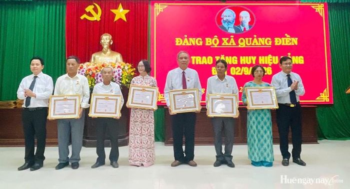 Thường trực Đảng ủy xã Quảng Điền trao Huy hiệu Đảng cho các đảng viên. Ảnh: Phong Anh