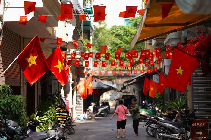 Tại nhiều con ngõ, khu dân cư, người dân treo Quốc kỳ trước cửa nhà, cửa hàng, khiến những không gian vốn quen thuộc cũng mang diện mạo khác trong những ngày cận Quốc khánh 2/9.