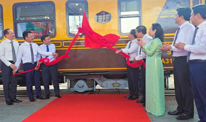 Các đại biểu thực hiện nghi thức gắn biển công trình chào mừng nghỉ niệm 145 năm Đường sắt Việt Nam và 80 năm Ngày truyền thống Đường sắt Việt Nam lên tàu du lịch Huế - Phong Nha tại buổi lễ.