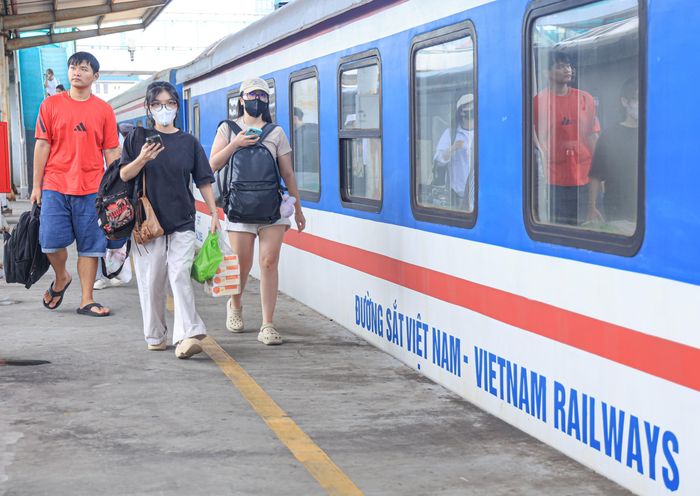 Hành khách lỉnh kỉnh hành lý vào ga đi tàu.