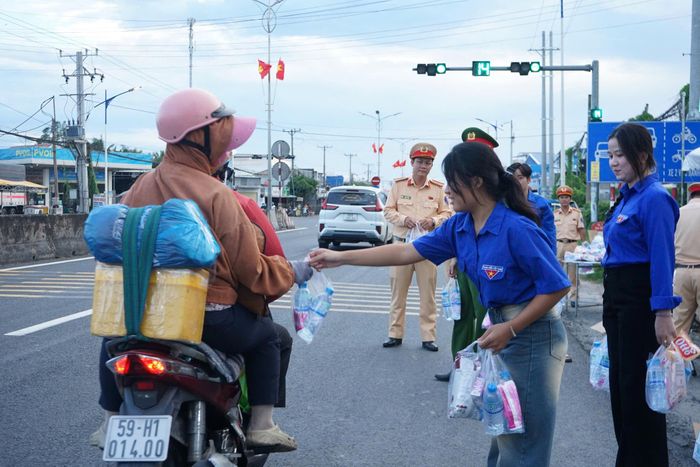 CSGT cùng đoàn viên thanh niên phát nước, bánh, khăn lạnh miễn phí trên QL1.