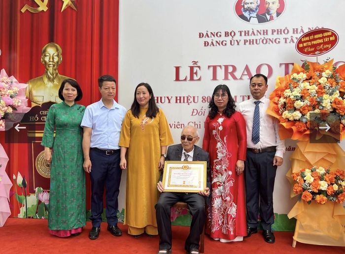 Đại diện UBND phường Tây Mỗ chúc mừng đồng chí Nguyễn Huynh nhân dịp đón nhận Huy hiệu 80 năm tuổi Đảng.