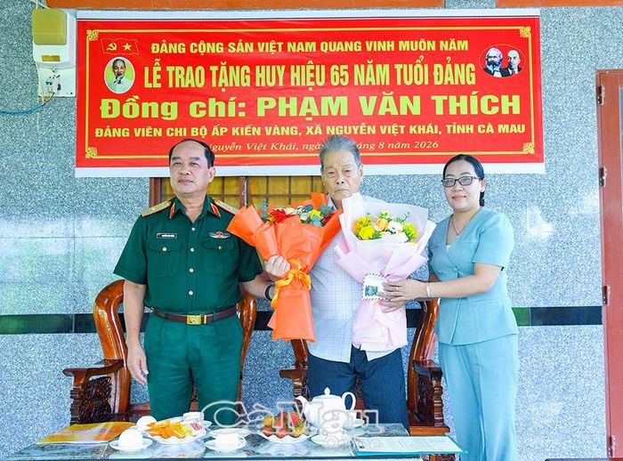 Thiếu tướng Nguyễn Văn Ngành, Uỷ viên Ban Thường vụ Tỉnh uỷ, Chỉ huy trưởng Bộ CHQS tỉnh Cà Mau và đồng chí Phạm Lý Ba, Bí thư Đảng uỷ Xã Nguyễn Việt Khái, tặng hoa chúc mừng đồng chí Phạm Văn Thích.