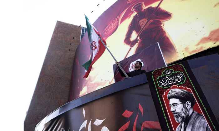 Người dân đi ngang tranh cổ động ở thủ đô Tehran, Iran - Ảnh: Reuters