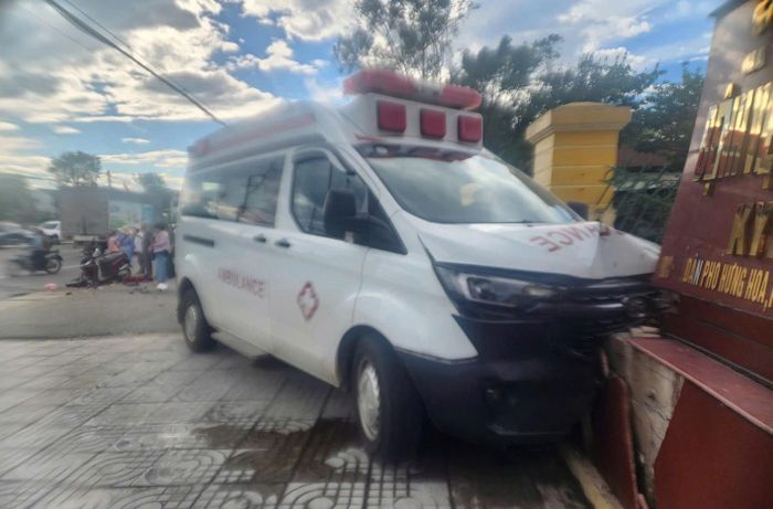 Chiếc xe cứu thương tiếp tục tông hỏng tường rào bệnh viện sau khi va chạm với xe máy. (Ảnh: H.T)