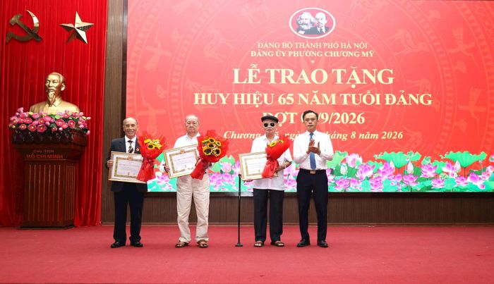 Bí thư Đảng ủy, Chủ tịch HĐND phường Chương Mỹ Phí Minh Hải trao Huy hiệu 65 năm tuổi Đảng tặng đảng viên sinh hoạt trên địa bàn phường. Ảnh: Kim Nhuệ