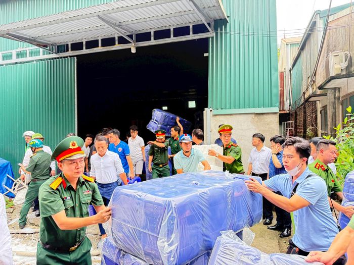 Các lực lượng sơ tán tài sản ra khỏi đám cháy. Ảnh: PV