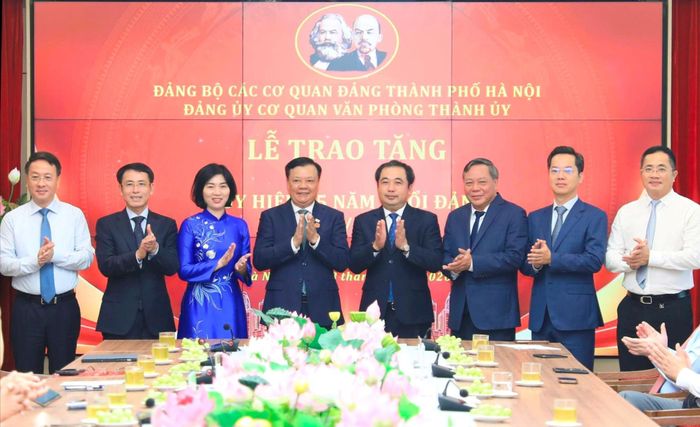 Bí thư Thành ủy Hà Nội Trần Đức Thắng và các đồng chí lãnh đạo thành phố Hà Nội chúc mừng đồng chí Đinh Tiến Dũng được trao tặng Huy hiệu 35 năm tuổi Đảng. Ảnh: Quang Thái