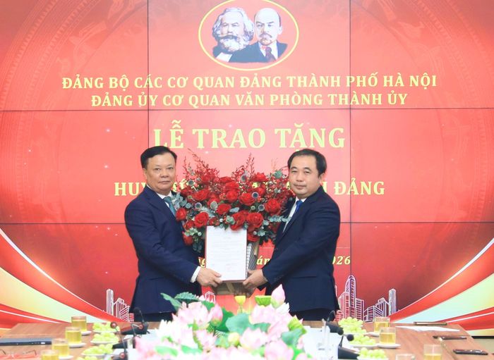 Bí thư Thành ủy Hà Nội Trần Đức Thắng trao Huy hiệu 35 năm tuổi Đảng tặng đồng chí Đinh Tiến Dũng. Ảnh: Quang Thái