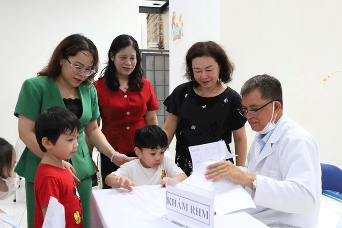 Phó Chủ tịch UBND phường Cửa Nam Trịnh Ngọc Trâm (áo xanh) kiểm tra công tác khám sức khỏe cho học sinh tại Trường Tiểu học Quang Trung. Ảnh: PV