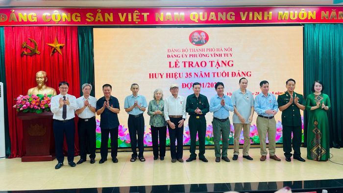 Lãnh đạo Đảng ủy phường Vĩnh Tuy trân trọng trao Huy hiệu 35 năm tuổi Đảng tặng các đồng chí đảng viên. Ảnh: Việt Thắng