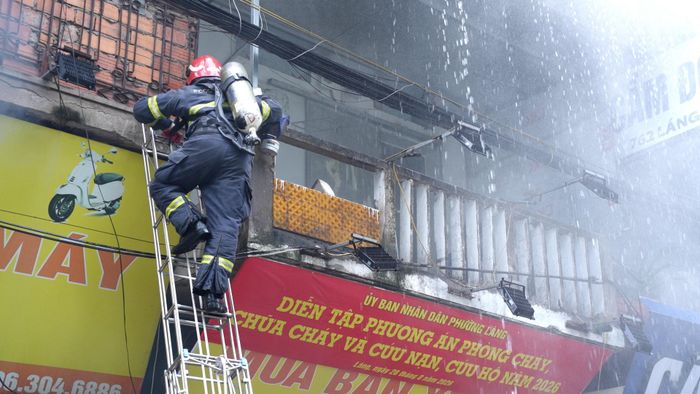 Lực lượng chuyên nghiệp sử dụng thang để tiếp cận ban công tầng 2. Ảnh: Phạm Mạnh
