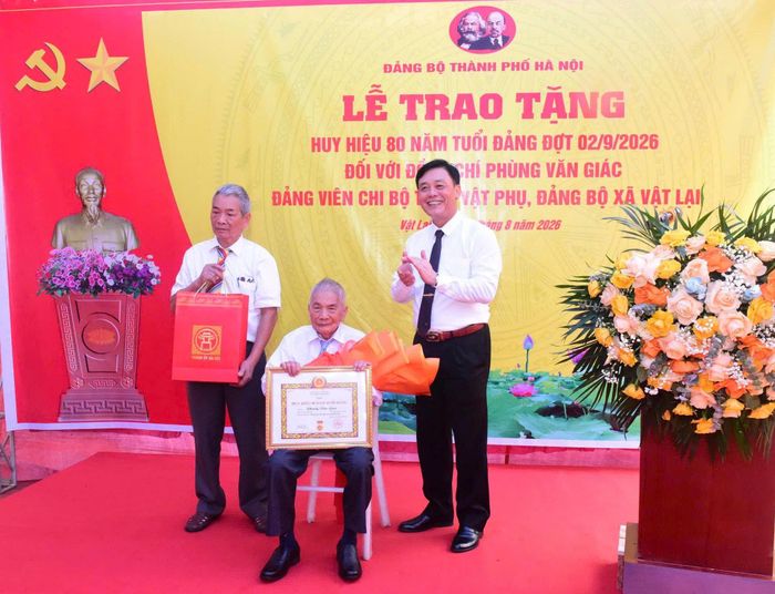Trung tướng Đào Văn Nhận, Ủy viên Ban Thường vụ Thành ủy, Tư lệnh Bộ Tư lệnh Thủ đô Hà Nội trao Huy hiệu 80 năm tuổi Đảng tặng đồng chí Phùng Văn Giác. Ảnh: Hữu Thu