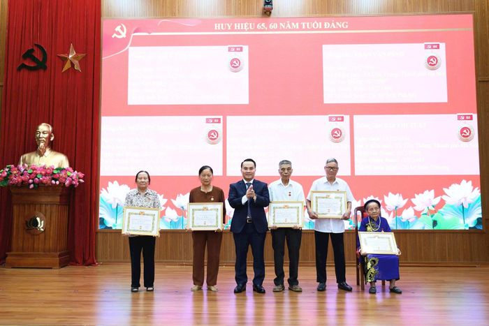 Lãnh đạo xã trao Huy hiệu 65, 60 năm tuổi Đảng tặng các đảng viên. Ảnh PV