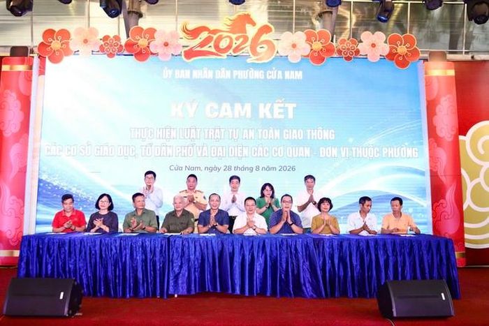 Trong khuôn khổ chương trình Lễ phát động Tháng An toàn giao thông sáng 28/8, đại diện các cơ quan, đơn vị, trường học trên địa bàn phường Cửa Nam thực hiện ký cam kết chấp hành các quy định về trật tự, an toàn giao thông. (Ảnh Thành Long)