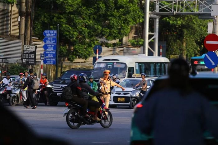 Trước mật độ phương tiện tăng cao, các chiến sĩ CSGT chủ động đứng giữa nút giao, hướng dẫn từng dòng xe di chuyển đúng hướng