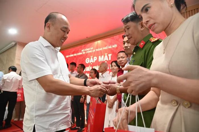 Đại tá Nguyễn Đức Long, Phó Giám đốc Công an thành phố Hà Nội tặng quà các đại biểu dự buổi gặp mặt
