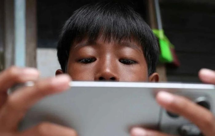  Một đứa trẻ tại Depok (Indonesia) sử dụng smartphone. Ảnh: Reuters. 