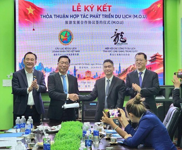 Ông Nguyễn Ngọc Tấn (ngoài cùng bên trái) và ông Thẩm Quảng Xuân (ngoài cùng bên phải) chứng kiến Lễ ký kết thoả thuận hợp tác du lịch giữa CLB Du lịch Doanh nhân trẻ Việt Nam và Hiệp hội các Công ty du lịch tỉnh Hắc Long Giang (Trung Quốc)