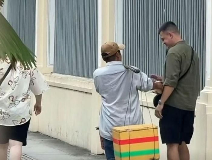 Người đàn ông liên tục chèo kéo, mời khách gánh dừa, mua dừa (Ảnh cắt từ clip)