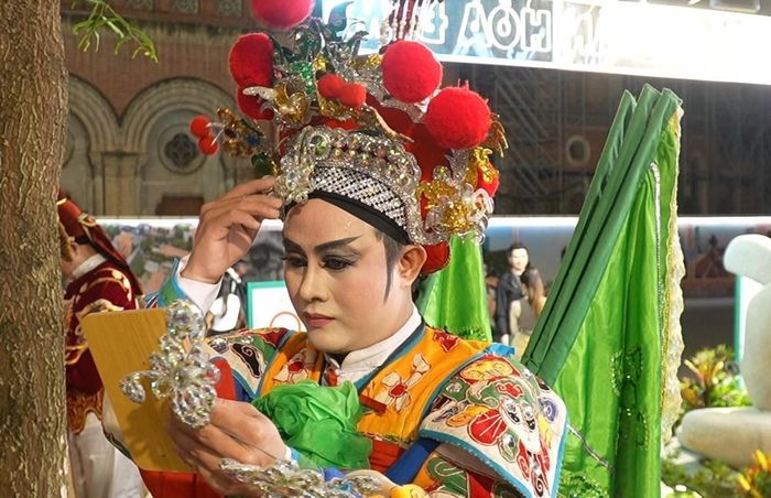 Nghệ sĩ hát bội vẽ mặt, đeo râu ngay trong không gian biểu diễn công cộng. Ảnh: Hữu Duyên - TTXVN