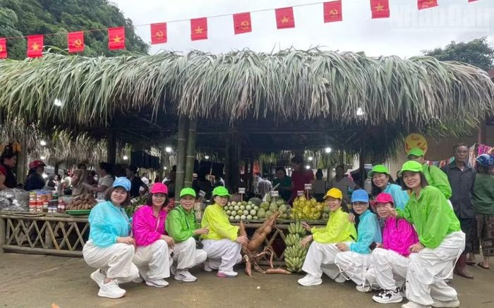 Các du khách chụp ảnh lưu niệm tại các gian hàng ở chợ phiên xã Muổi Nọi. (Ảnh: QUỐC TUẤN)